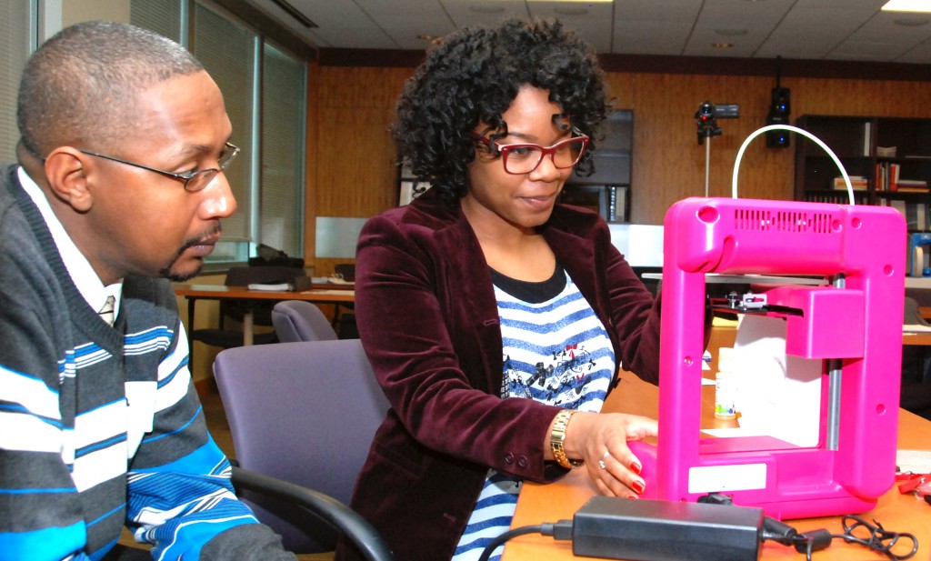 Ivan Tucker and Joi Toliver from South Carolina Youth ChalleNGe Academy look at a Cube 3D printer