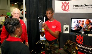 YouthQuest Director of Instruction Tom Meeks watches as Freestate Cadet Requan Da Sant operates a 3D scanner at YouthQuest's booth at the USA Science & Engineering Festival in Washington, DC, April 25, 2014. 