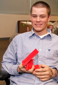 3D ThinkLink Lab student Caleb Dujmovic from Freestate ChalleNGe Academy with a cell phone stand he created