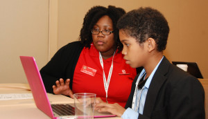 3D ThinkLink instructor La-Toya Hamilton from Capital Guardian Youth ChalleNGe Academy shows a student how to use Moment of Inspiration 3D modeling software during a workshop of the National Society of Black Engineers Convention in Anaheim, March 26, 2015