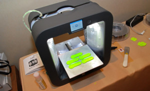 A Cube 3 printer makes a batch of key chain tags designed by students in YouthQuest 's 3D printing workshops at the National Society of Black Engineers Convention in Anaheim March 26, 2015