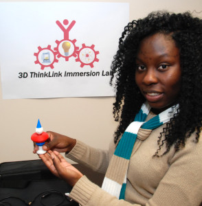 South Carolina Youth ChalleNGe Academy graduate Sherquana Adams holds one of her 3D-printed creations in YouthQuest's 3D ThinkLink immersion lab August 2014