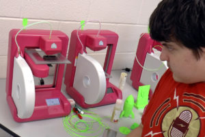 Henry Spiegelblatt runs a 3D printer in YouthQuest's 3D ThinkLink class at the PHILLIPS School in Annandale, Virginia