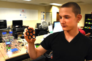 Freestate ChalleNGe Academy Cadet David Kelly holds a frame for a fidget spinner he 3D printed during immersion training week in YouthQuest's 3D ThinkLink Creativity Lab June 2017