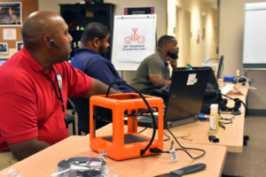 Capital Guardian's Keith Hammond and Freestate's Jonathan Brown and Jamarr Dennis learn about the M3D Micro 3D printer during 3D ThinkLink Teacher Training on Sept. 26, 2017.