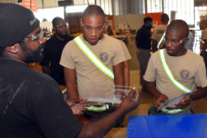 Eric Smith, who led a Vocational Orientation tour of The Foundery for our 3D ThinkLink students from Maryland's Freestate ChalleNGe Academy on October 9, 2018, shows acrylic panels that were etched by a laser cutter.