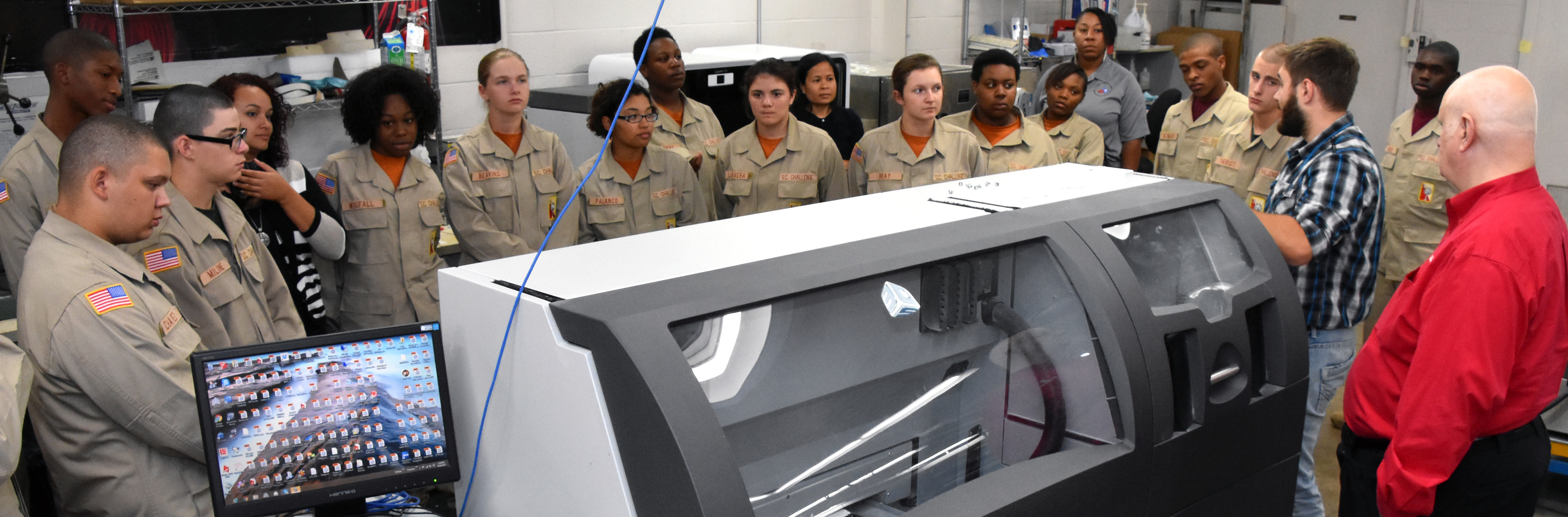 3D ThinkLink students from South Carolina Youth ChalleNGe Academy look at an industrial 3D printer during Vocational Orientation